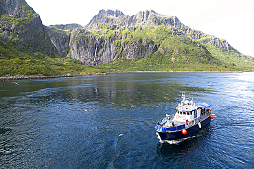 Small tourist boat in mountainous fiord landscape, Raftsundet Strait, Nordland, northern Norway, Scandinavia, Europe