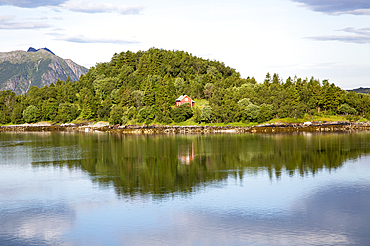 Isolated coastal house on small wooded island near Ornes, Nordland, Norway, Scandinavia, Europe