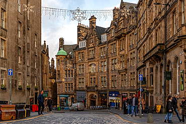 Historic buildings line a bustling street in Edinburgh's old town, with pedestrians and traditional architecture, Edinburgh, Lothian, Scotland, United Kingdom, Europe