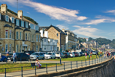 Quaint European street with historic buildings, parked cars, and a clear blue sky in Filey, England.