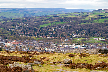 Scenic view of a quaint town nestled in a lush valley with rolling hills in the background and rocky terrain in the foreground in Ilkley, North Yorkshire, England, United Kingdom, Europe