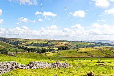 Idyllic rural landscape with stone walls, rolling hills, and a clear sky with contrails, depicting serene countryside in Yorkshire Dales, Yorkshire, England, United Kingdom, Europe