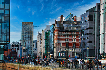 Modern cityscape with diverse architecture and pedestrians on a sunny day in Liverpool, UK.