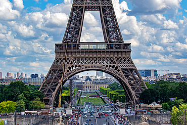 Scenic view of the Eiffel Tower on a sunny day with blue skies and fluffy clouds, bustling with tourists, Paris, France, Europe