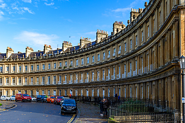 Historic Georgian crescent architecture with parked cars on a sunny day in Bath, Somerset, England, United Kingdom, Europe