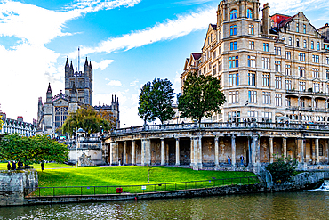 Historic cityscape with Abbey, classic architecture, and riverfront promenade under a blue sky, Bath, Somerset, England, United Kingdom, Europe