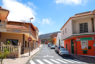 Quaint street in a sunny town with traditional houses and parked cars, clear blue sky above in Tenerife, Canary Islands, Spain, Atlantic, Europe