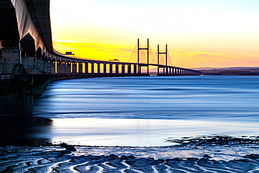 Long exposure of a serene sunset over the Prince of Wales Bridge, the Second Severn Crossing, M4 motorway over the River Severn, clear skies, and warm sunlight, between England and Wales, United Kingdom, Europe