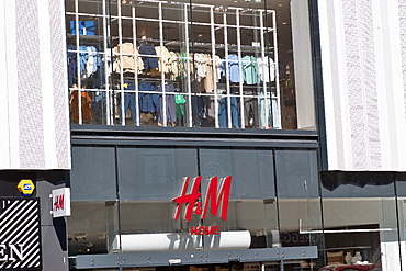 Exterior view of an H&M store front with clothing displayed in the window and the store logo prominently featured in Liverpool, UK.