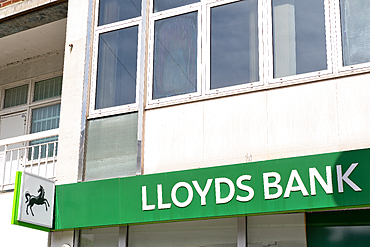 A partial view of a Lloyds Bank building, featuring the sign, windows, and adjacent building detail in daylight in Kingston, UK.