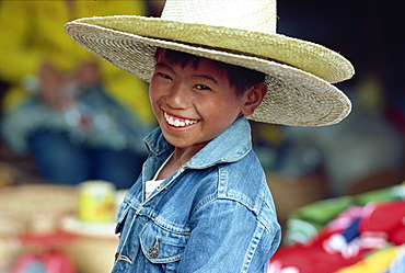 Portrait of a smiling boy wearing a denim jacket and two straw hats in Baguio City, northern Luzon, the Philippines, Southeast Asia, Asia