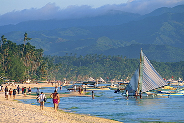 Tourists and outrigger canoes on White Sun Beach, at the resort of Boracay Island, off Panay, the Philippines, Southeast Asia, Asia