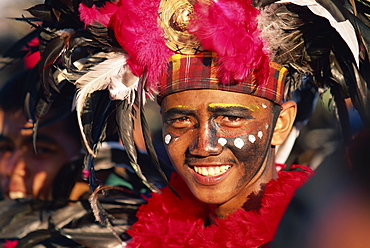 Portrait of a man with facial decoration and head-dress with feathers at Mardi Gras carnival, Dinagyang in Iloilo City on Panay Island, Philippines, Southeast Asia, Asia