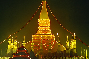 Lights illuminate the Great Stupa of Pha That Luang at full moon in Makkha Bu Saa, Buddhist Lent, in Vientiane, Laos, Indochina, Southeast Asia, Asia