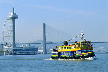 Ferry on the Tejo River near the Expo 98 Park, with the Vasco da Gama Tower and the Vasco da Gama Bridge behind, in Lisbon, Portugal, Europe