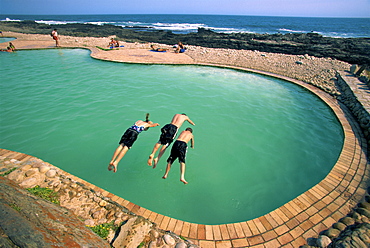 Three children diving into a swimming pool, South Africa, Africa