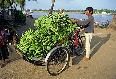 Green bananas being off-loaded at port for transportation by cyclo to market in Cambodia, Indochina, Southeast Asia, Asia