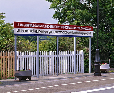 Station sign at Llanfairpwllgwyngyllgo-gerychwyrndrobwllllantysiliogogogoch (Llanfair-PG.), Anglesey, North Wales, United Kingdom, Europe