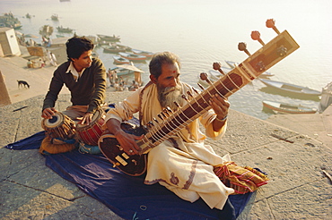 Musicians playing the Sitar and Tabla on the banks of the River Ganges (Ganga), Varanasi (Benares), Uttar Pradesh State, India