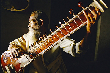 Portrait of an elderly man playing the sitar, India