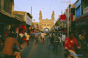 Street scene with bicycles and rickshaw and the Char Minar (Charminar) triumphal arch built in 1591, Hyderabad, Andhra Pradesh State, India