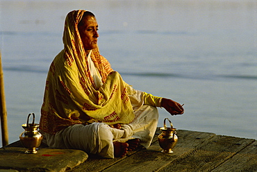 Woman meditating on the banks of the River Ganges, Varanasi, Uttar Pradesh state, India, Asia