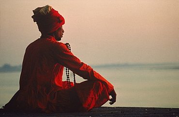 Man with rosary meditating on the banks of the River Ganges, Varanasi, Uttar Pradesh state, India, Asia