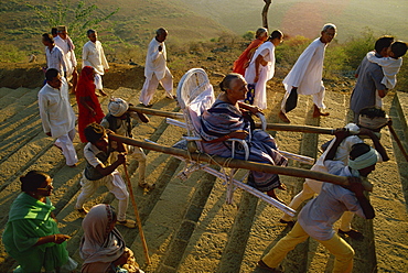 Jain pilgrims walking and being carried up the sacred hill of Palitana, Gujarat state, India, Asia