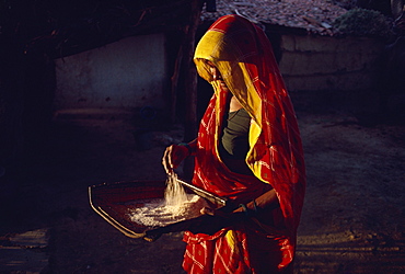 Woman cleaning rice for evening meal, Gujarat, India, Asia