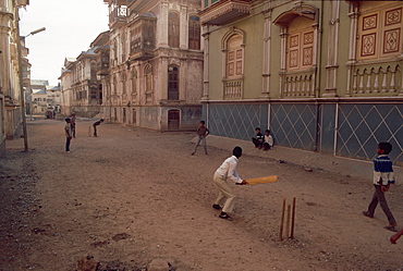 Children play cricket in the street, Sidpur, India, Asia