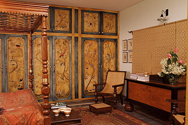 Colonial style bed, antique South Indian storage box, hand painted cupboards in home in Dehra Dun, Himalayan foot hills, Uttar Pradesh state, India, Asia