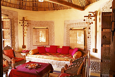 Raised mud reliefs inlaid with mirror on the walls of living area in modern home in traditional tribal Rabari round mud hut, Bunga style, near Ahmedabad, Gujarat state, India, Asia