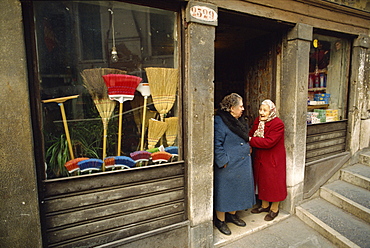 Two old ladies talking in the doorway of a broom shop in Venice, Veneto, Italy, Europe