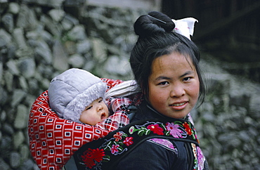 Portrait of a Miao mother and baby, baby carrier has embroidered straps, Guizhou Province, China, Asia