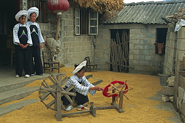 Bouyei girl winding a bobbin for weaving, south Guizhou, Guizhou, China, Asia