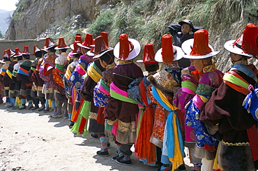 Line of people wearing Tibetan traditional dress, Tongren, Qinghai Province, China, Asia