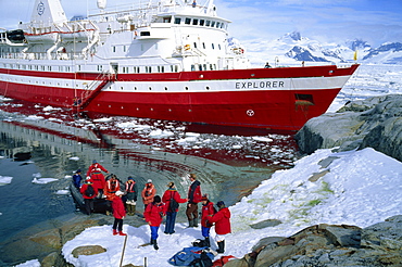 Passengers take small boat to the Explorer cruise ship anchored close inshore, on the Antarctic Peninsula, Antarctica, Polar Regions