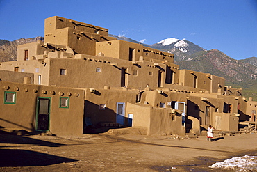 Woman sweeping up, in front of the adobe buildings of the north complex, dating from 1450, Taos Pueblo, UNESCO World Heritage Site, New Mexico, United States of America, North America