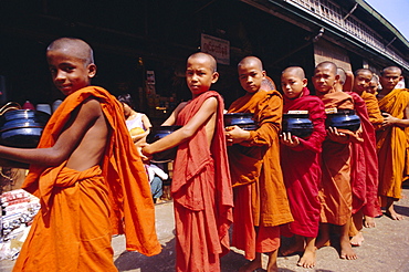 Young Buddhist monks carrying bowls in the street, Yangon (Rangoon), Myanmar (Burma), Asia