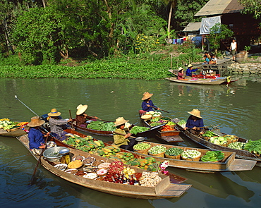 Women in straw hats in boats loaded with fruit, vegetables and groceries, at a floating market on a canal in Thailand, Southeast Asia, Asia