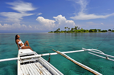 Girl on a traditional boat and the islet off the coast of Bohol, Philippines, Southeast Asia, Asia