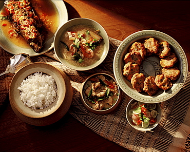 A typical Thai meal balancing spicy, sour and sweet flavours, consisting of spicy thom yam soup, weet and sour fish, fish patties, a curry dish and rice, Thailand, Southeast Asia, Asia