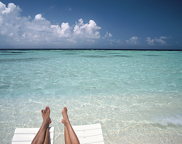 Couple's legs on a beach, Maldives, Indian Ocean, Asia