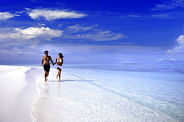 Couple running on a beach, Maldives, Indian Ocean, Asia