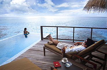 Couple relaxing on the terrace, Maldives, Indian Ocean, Asia