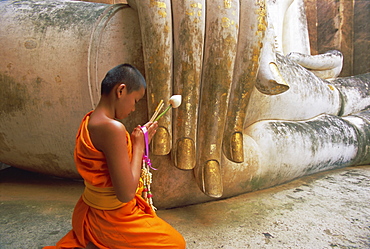 Novice Buddhist monk and Phra Atchana Buddha statue, Wat Si Chum, Sukhothai, UNESCO World Heritage Site, Sukhothai Province, Thailand, Asia