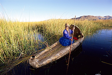 A Uros Indian woman in a traditional reed boat, Islas Flotantes, floating islands, Lake Titicaca, Peru, South America