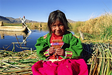 Portrait of a Uros Indian girl holding pan pipes, Islas Flotantes, Lake Titicaca, Peru, South America