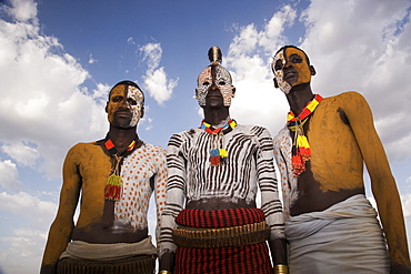 Portrait of three Karo tribesmen with faces and bodies painted with chalk imitating the spotted plumage of the guinea fowl, Omo river, Lower Omo Valley, Ethiopia, Africa