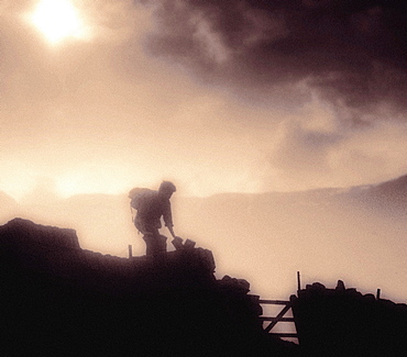 A walker descending Bowfell, Lake District, Cumbria, UK